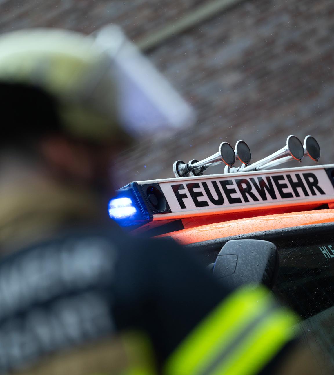 Symbolbild: Eine Einsatzkraft der Feuerwehr steht im Hof der Feuerwache 5 Filder vor einem Einsatzfahrzeug (gestellte Szene).