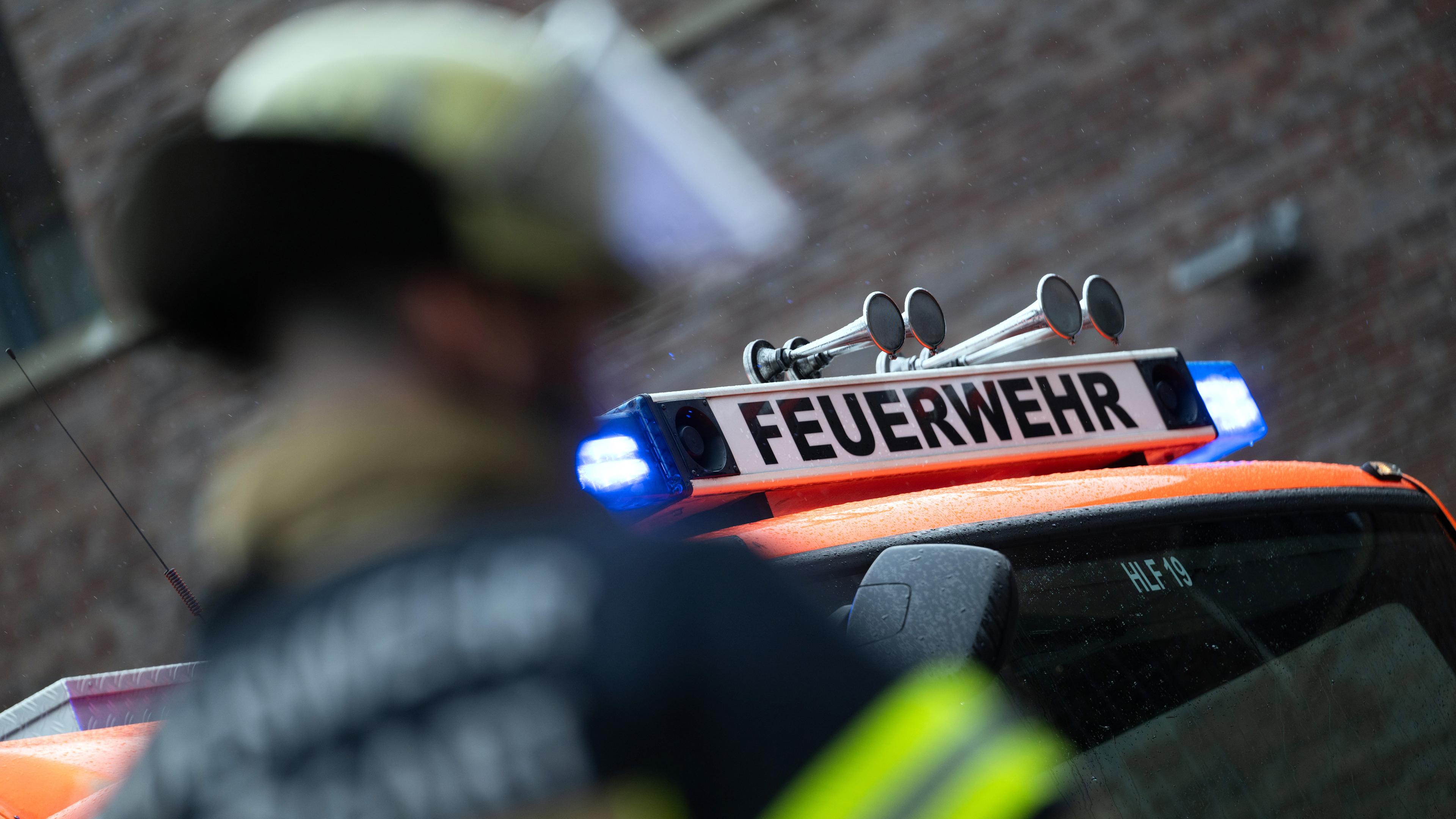 Symbolbild: Eine Einsatzkraft der Feuerwehr steht im Hof der Feuerwache 5 Filder vor einem Einsatzfahrzeug (gestellte Szene).