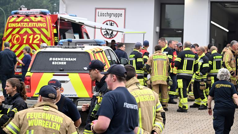 Feuerwehrleute warten an der Einsatzleitung in Kalterherberg auf ihren Einsatz am 17.08.2026 in Monschau, Nordrhein-Westfalen.