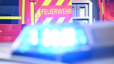 Zwei Feuerwehrfahrzeuge, das vordere hat sein Blaulicht aktiviert. 