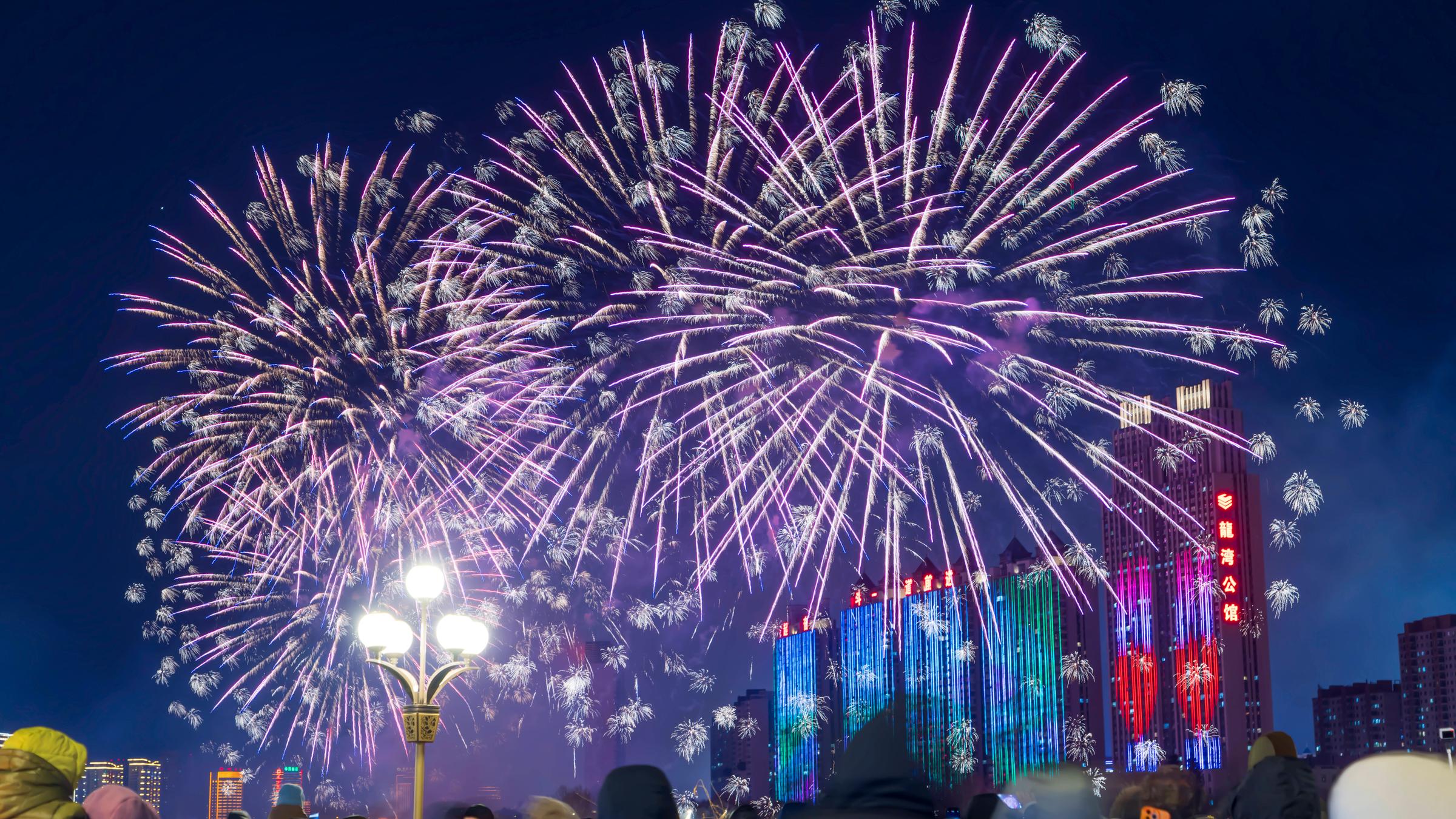 Menschen beobachten das Feuerwerk entlang des Songhua-Flusses an Silvester am 31.12.2025 in Jilin, Provinz Jilin, China.