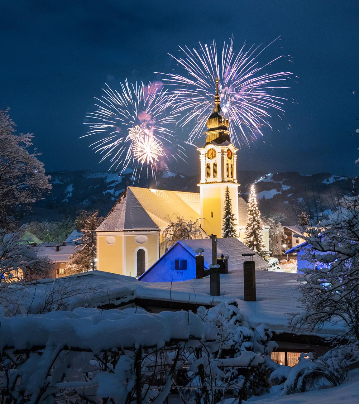 Kirche in verschneiter Winterlandschaft mit Feuerwerk in Sonthofen, Deutschland. (Archiv)