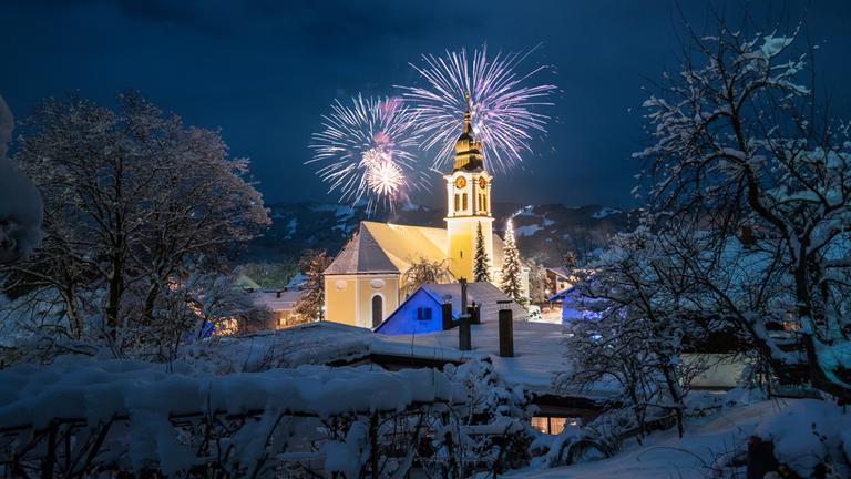 Kirche in verschneiter Winterlandschaft mit Feuerwerk in Sonthofen, Deutschland. (Archiv)