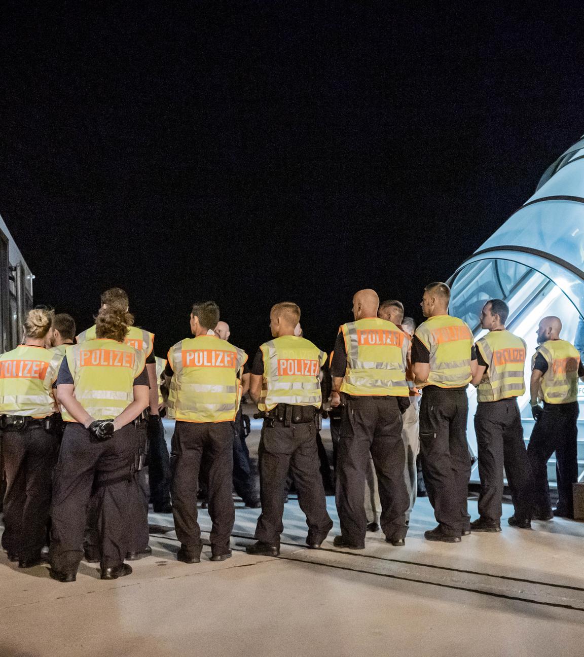 polizeibeamte begleiten einen afghanen auf dem flughafen leipzig-halle in ein charterflugzeug.