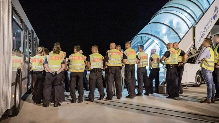 polizeibeamte begleiten einen afghanen auf dem flughafen leipzig-halle in ein charterflugzeug.