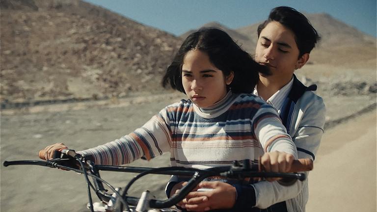 Ein Mädchen und ein Junge fahren auf einem Motorrad.