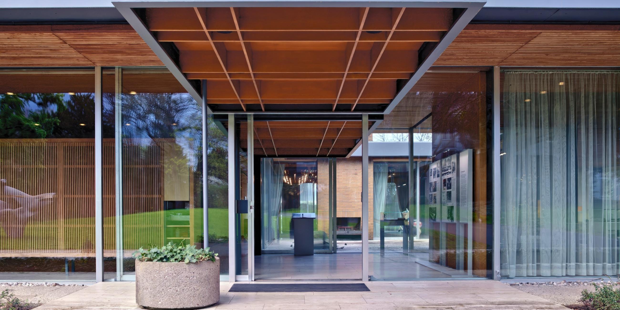 Ein moderner Bungalow mit viel Glas und Holzdecken.
