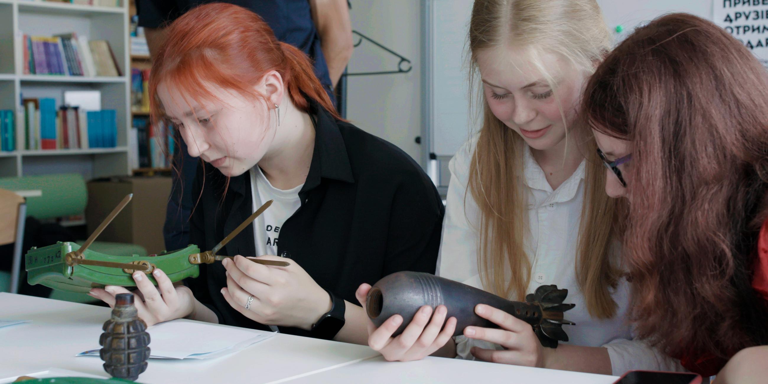 Mädchen sitzen an einem Tisch und halten Sprengsätze in den Händen.