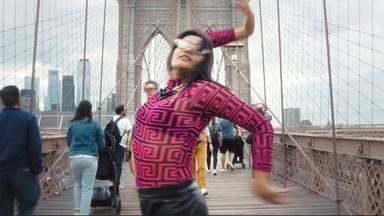 Eine Frau tanzt auf der Brooklyn Bridge in New York