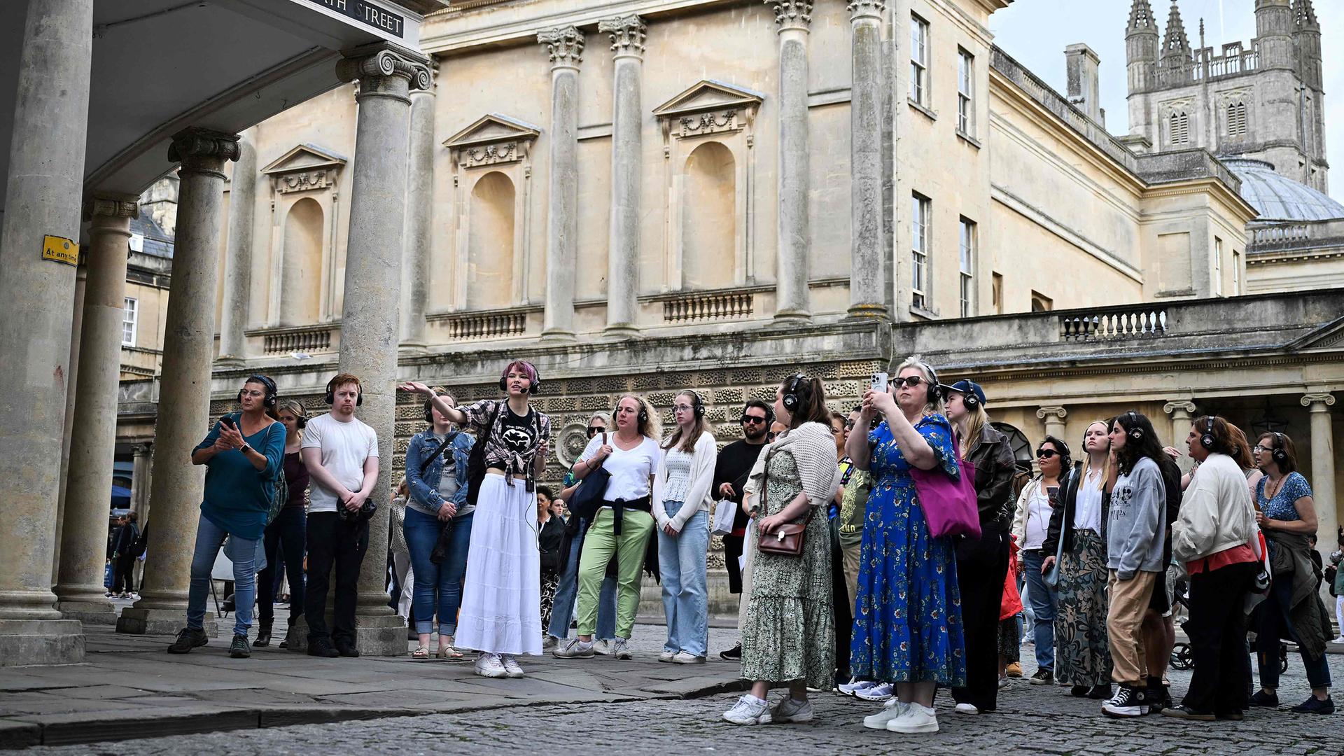 Besucher hören der Reiseleiterin Ruby Maidment zu, während sie am 16. Juli 2024 die Sets der Netflix-Serie "Bridgerton" in Bath, Westengland, entdecken am 16.07.2024 