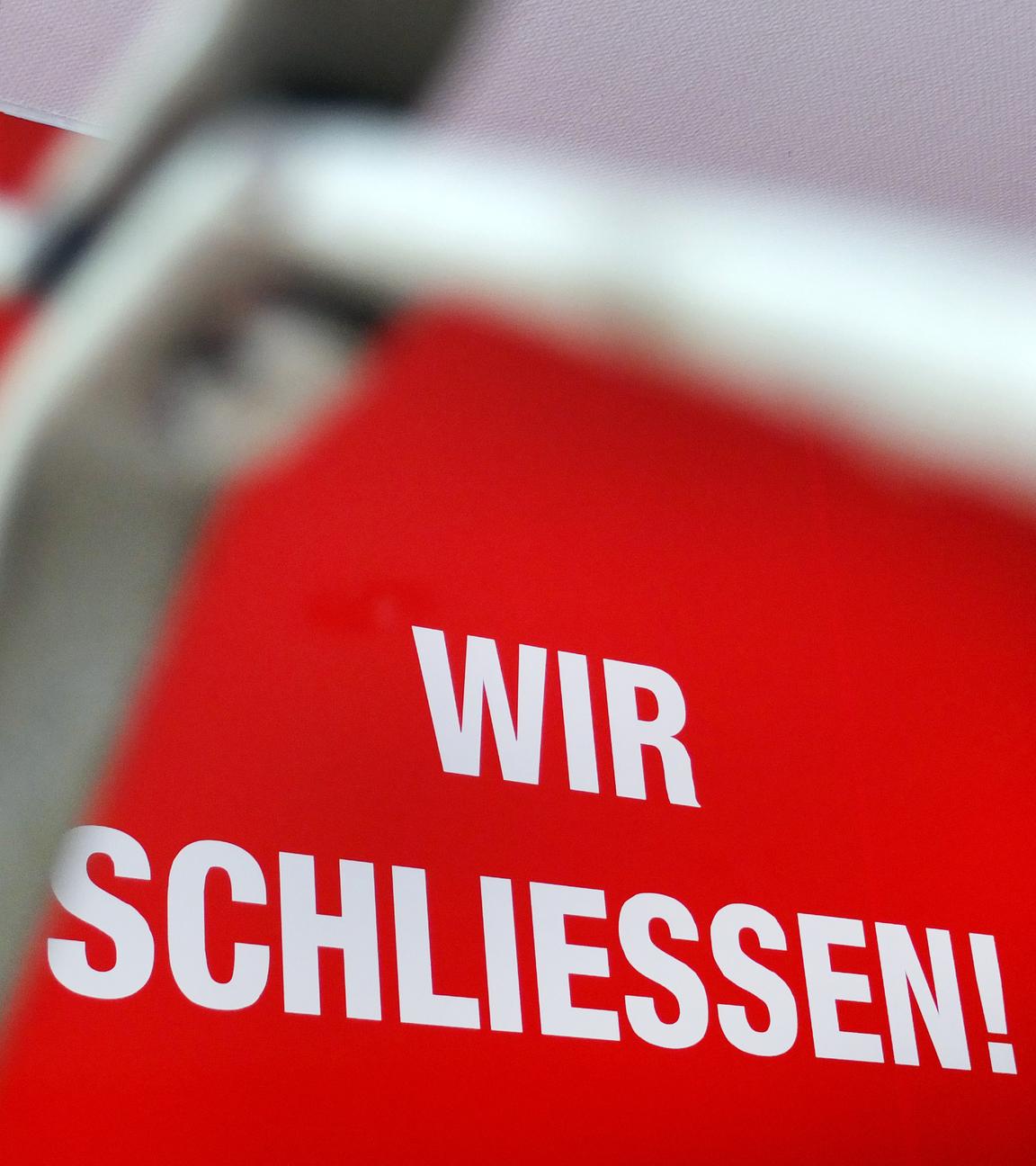 ARCHIV - 27.06.2012, Nordrhein-Westfalen, Düsseldorf: Der Schriftzug «Wir Schliessen» steht hinter einem Rollgitter an einem geschlossenen Geschäft.