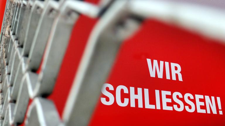 Der Schriftzug "Wir Schliessen" steht hinter einem Rollgitter an einem geschlossenen Geschäft in Düsseldorf, am 27.06.2012.