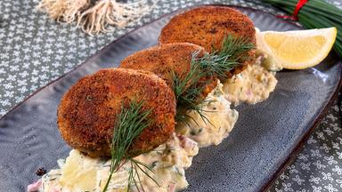 Fischfrikadellen auf Kartoffel-Gurken-Salat serviert.
