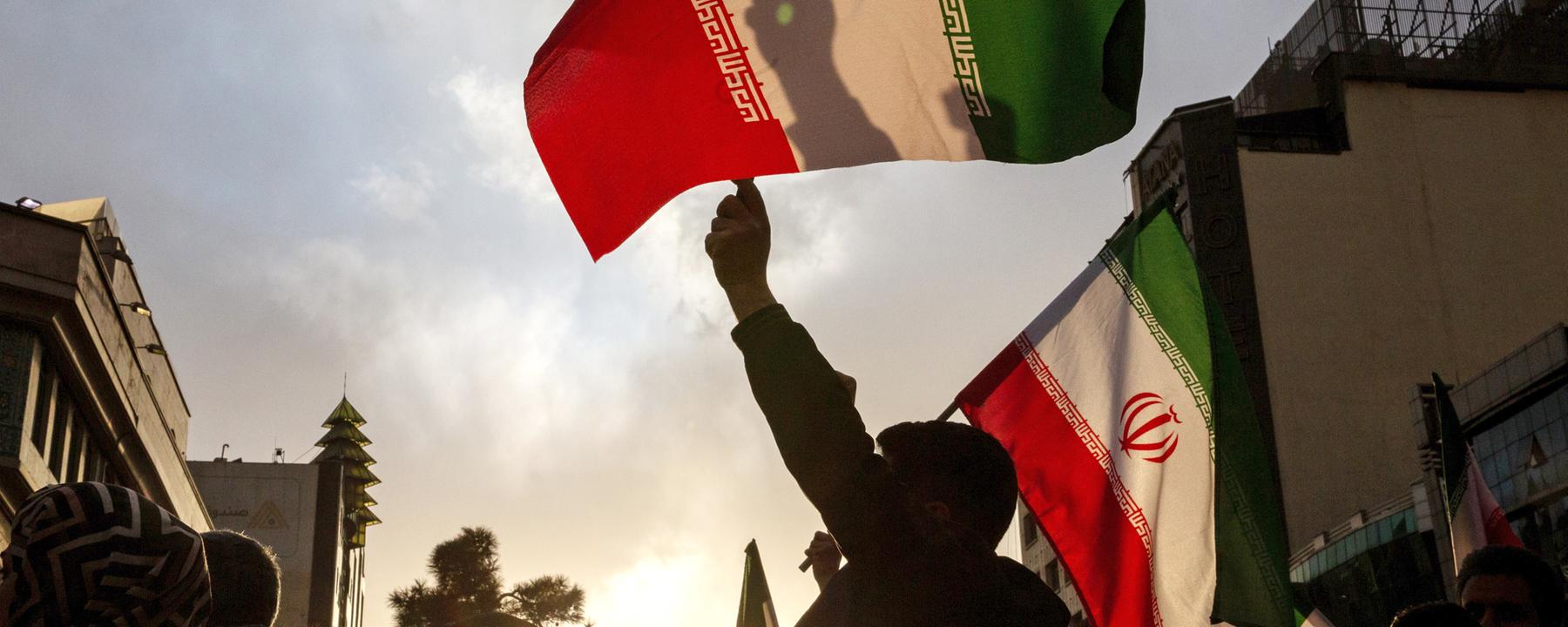 Die Teilnehmer einer Kundgebung schwenkten iranische Flaggen, aufgenommen am 28.02.2026