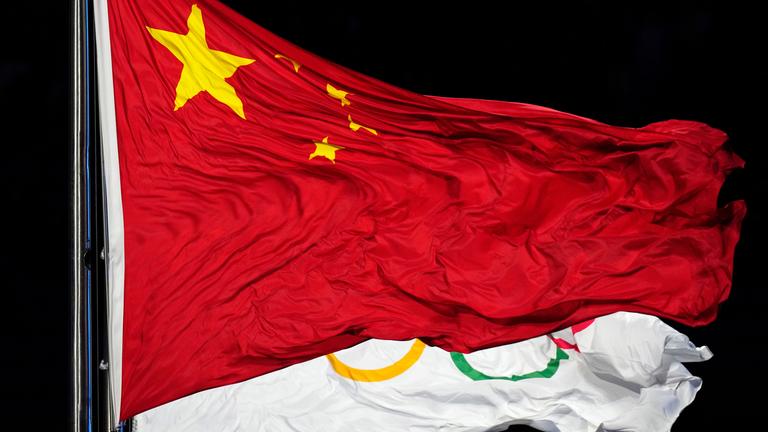 Chinas Flagge vor der Olympischen Flagge