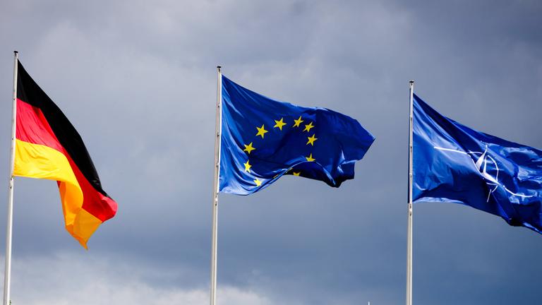 Die Flaggen von Deutschland, Europa und Nato wehen vo dem Reichstagsgebäude in Berlin. (Archiv)