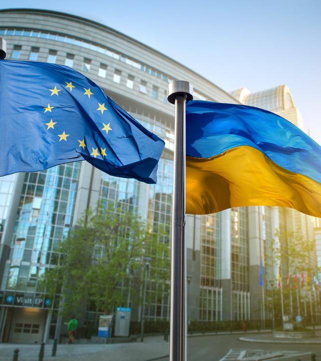 Flaggen der Ukraine und der Europäischen Union wehen im Wind in Brüssel.