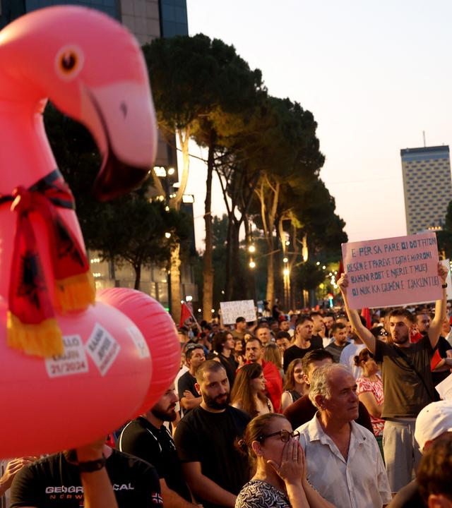 People demonstrate holding an inflatable flamingo and placards in front of Albania's Prime Minister's office against a planned resort linked to US President's family, in Tirana on June 27, 2026. Since late May, protesters have gathered every evening to oppose the construction of a luxury hotel linked to Trump's daughter Ivanka and her husband Jared Kushner, planned in a nature reserve on the Balkan nation's coast.