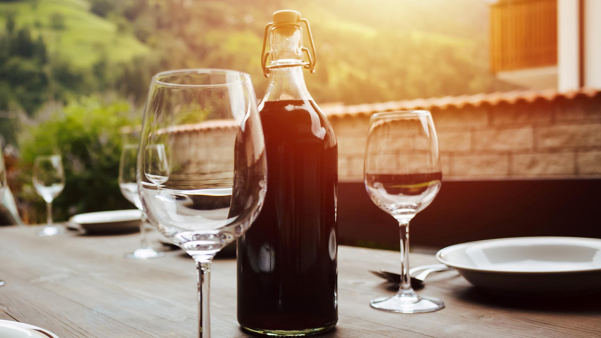 Flasche Rotwein und gedeckter Tisch