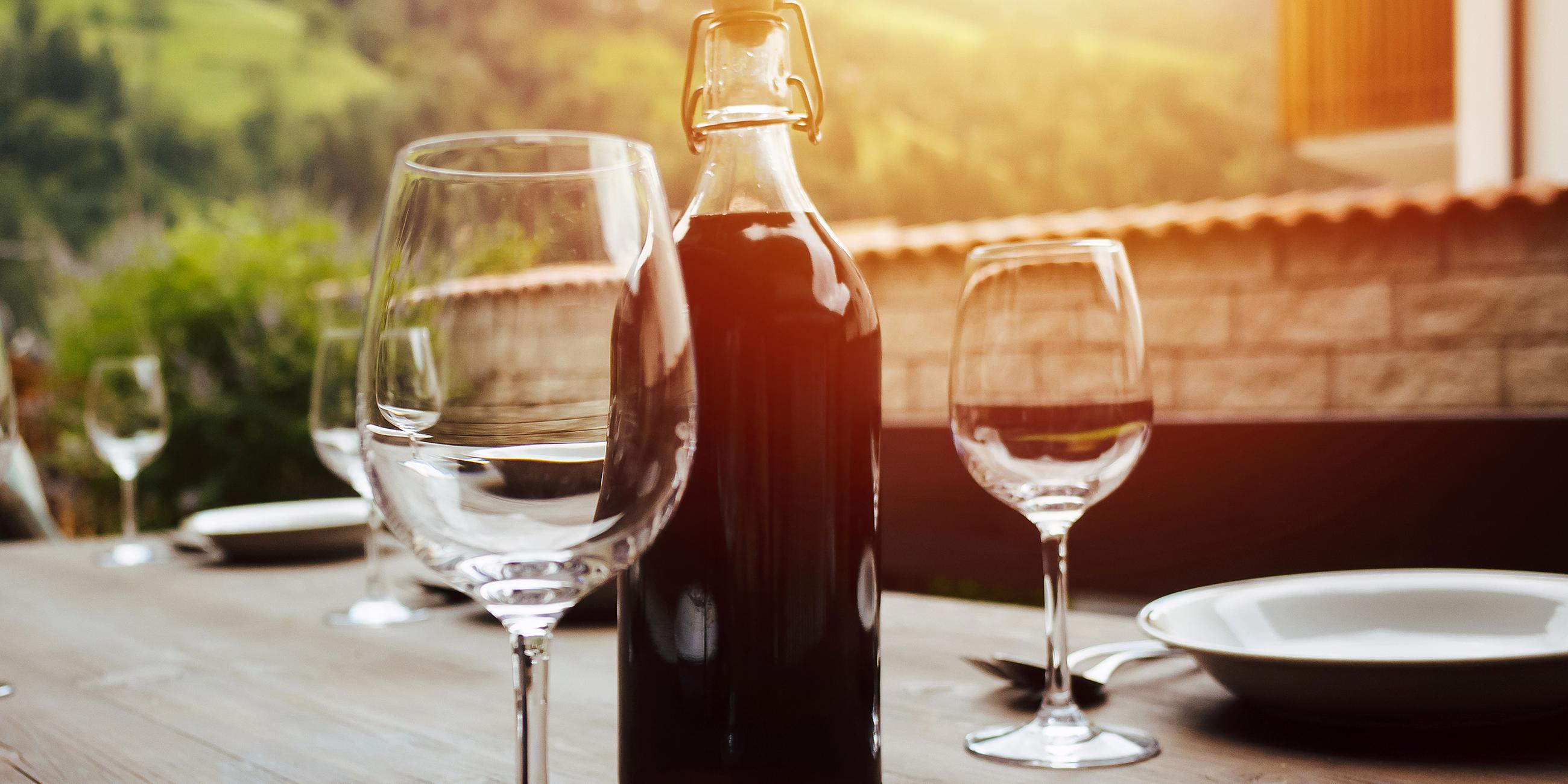 Flasche Rotwein und gedeckter Tisch