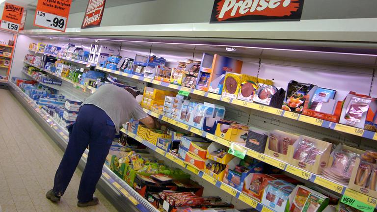 Konsument steht an der Kühltheke mit Fleisch- und Wurstwaren