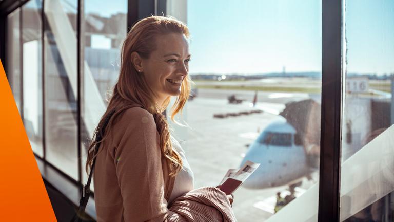Frau steht entspannt am Flughafen