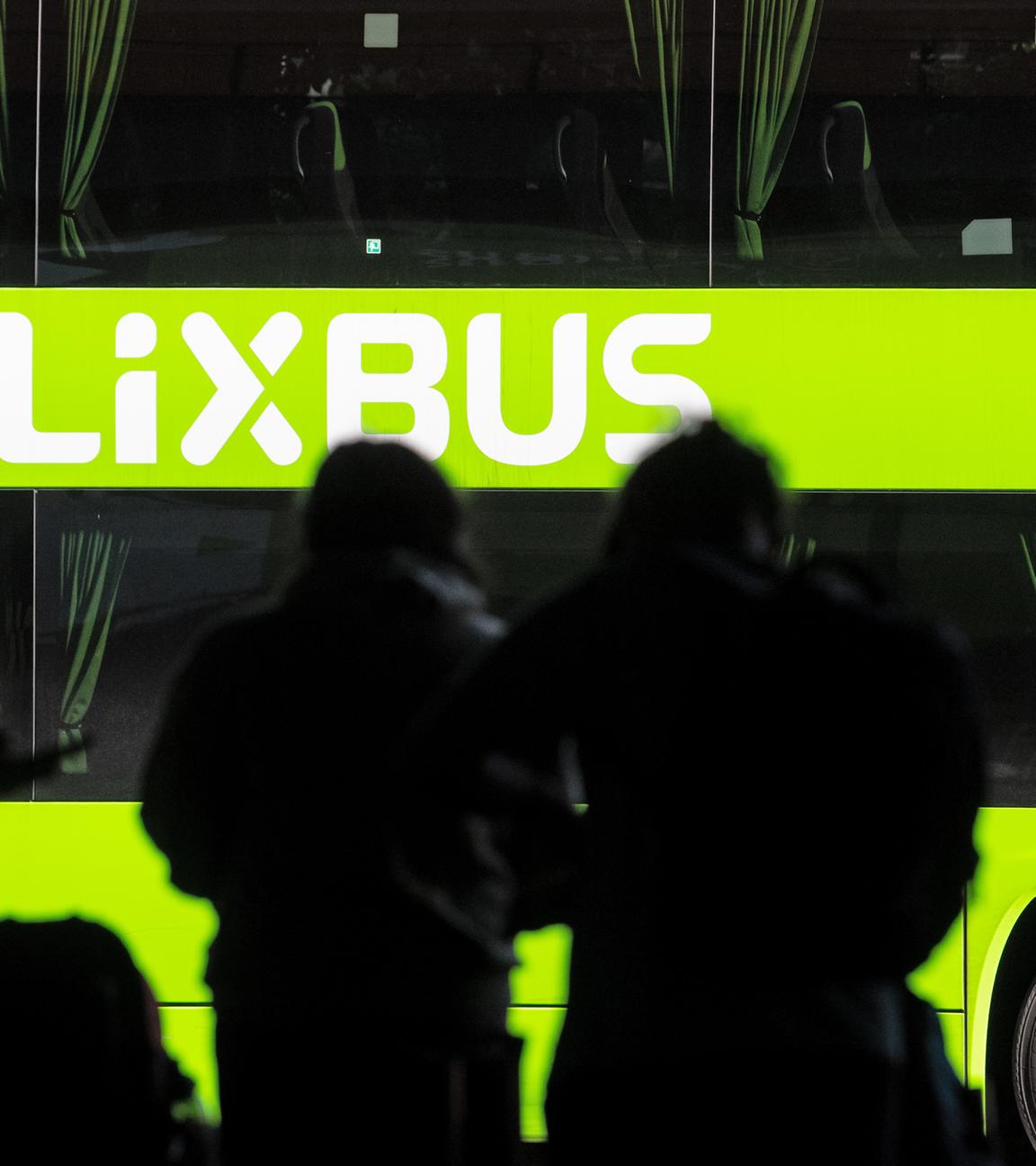 Reisende warten vor einem Bus des Fernbusanbieters Flixbus.