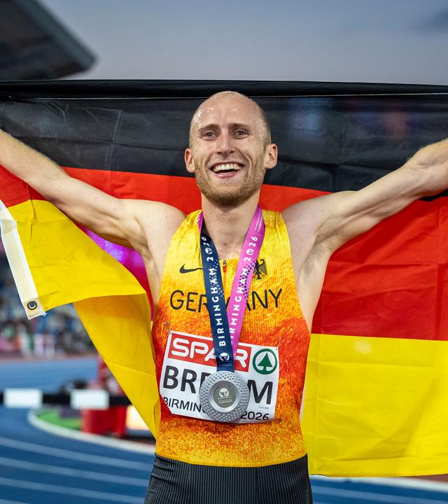 Florian Bremm mit Fahne und Silbermedaille nach dem Wettkampf über 5000m bei der EM in Birmingham.