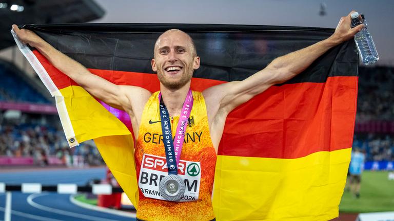Florian Bremm mit Fahne und Silbermedaille nach dem Wettkampf über 5000m bei der EM in Birmingham.