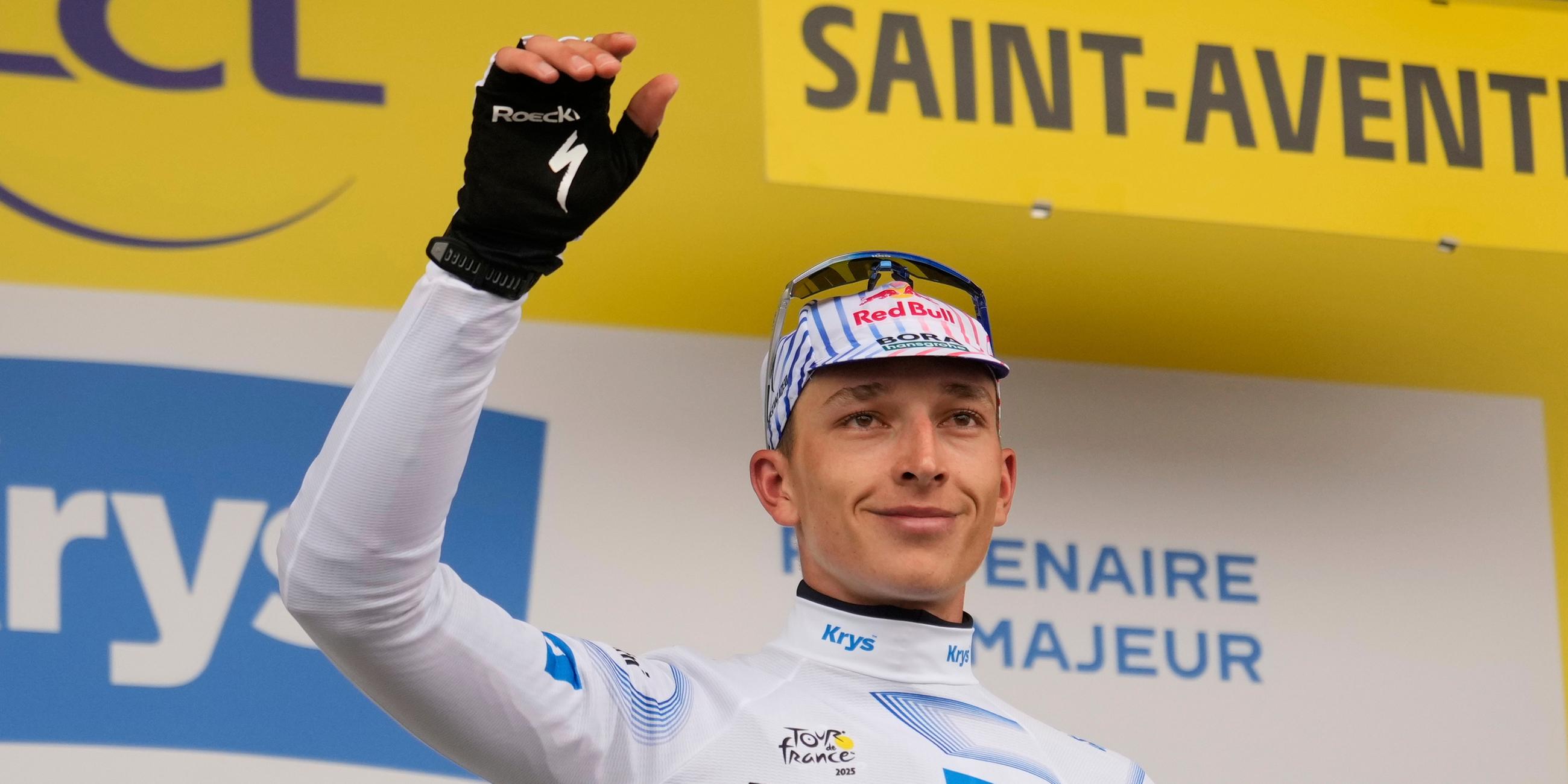 Der Deutsche Florian Lipowitz, der das Weiße Trikot des besten Nachwuchsfahrers trägt, feiert auf dem Podium.