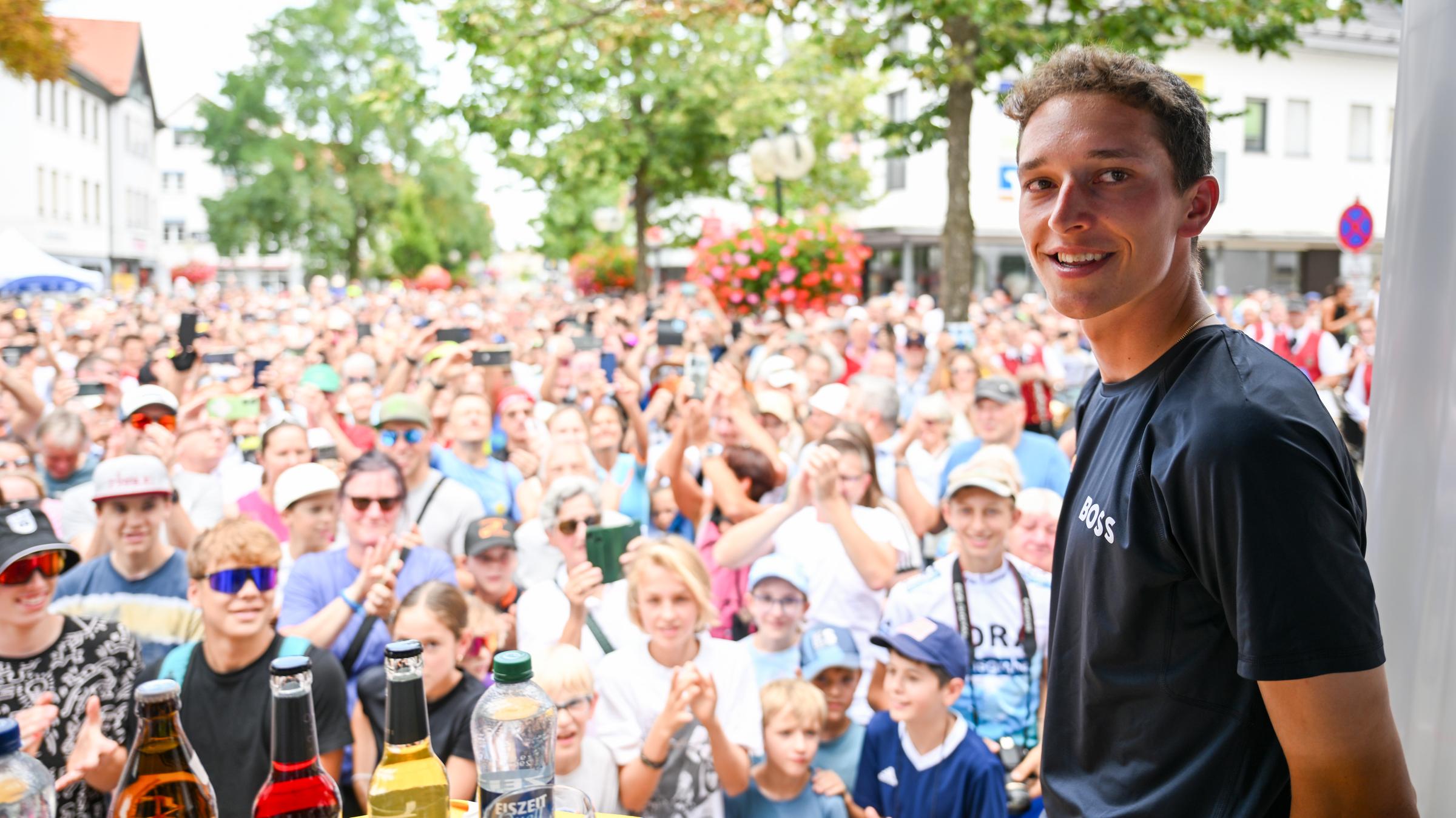 Rennrad-Profi Florian Lipowitz steht in seiner Heimatstadt Laichingen vor hunderten Menschen auf einer Bühne.