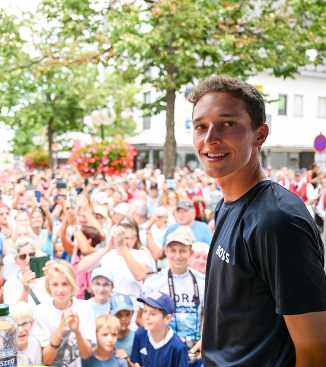 Rennrad-Profi Florian Lipowitz steht in seiner Heimatstadt Laichingen vor hunderten Menschen auf einer Bühne.