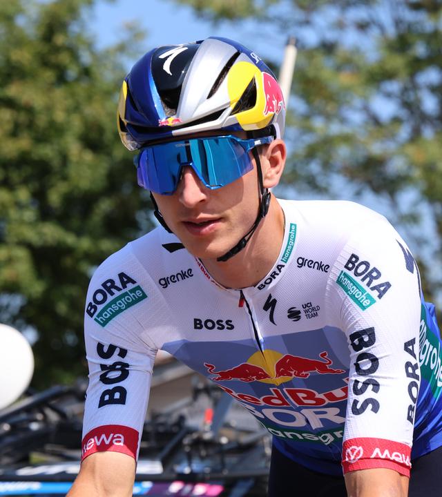 Radfahrer im blauen Trikot und mit Sonnenbrille fährt in Richtung Kamera