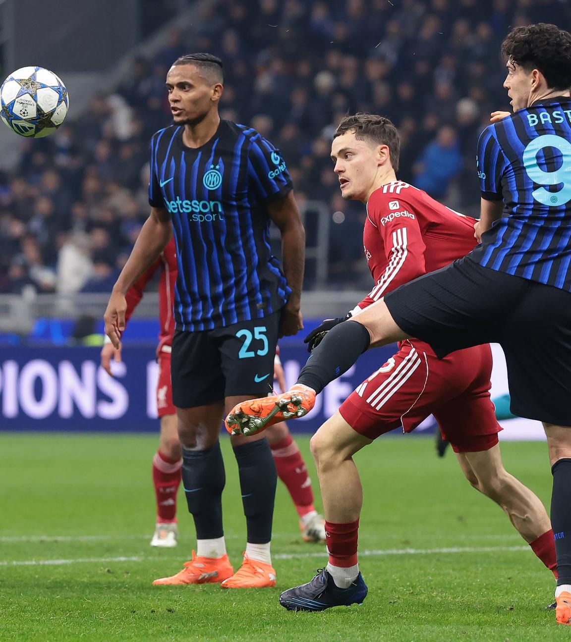 Im Zweikampf wird Liverpools Stürmer Florian Wirtz von Inter Mailands Verteidiger Alessandro Bastoni am Trikot gezogen und bei der Ballmitnahme gestört.