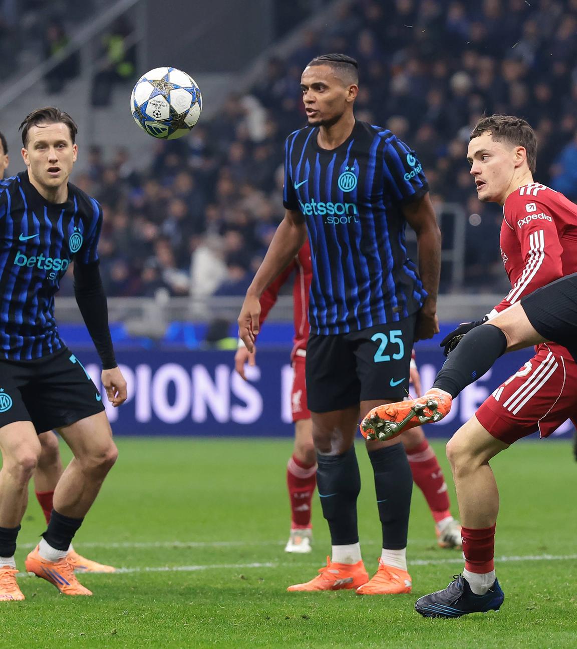 Im Zweikampf wird Liverpools Stürmer Florian Wirtz von Inter Mailands Verteidiger Alessandro Bastoni am Trikot gezogen und bei der Ballmitnahme gestört.