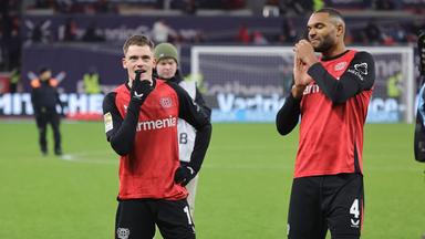 Fußballer Florian Wirtz und Jonathan Tah (Bayer Leverkusen) stehen am 16.05.2025 enttäuscht nach Spielschluß auf dem Feld.