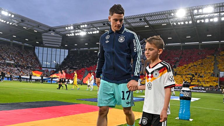 Fußballer Florian Wirtz kommt mit einem Einlaufkind am 31.05.2026 im Freundschafts-Länderspiel gegen Dänemark in die Mewa-Arena in Mainz.