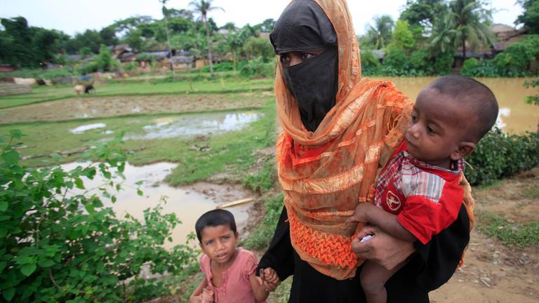 Mutter verschleiert mit kund auf Arm und an der Hand