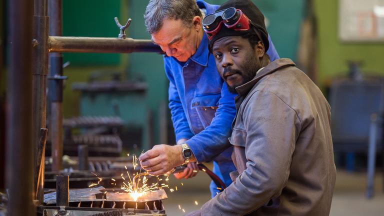 Der aus Gambia stammende Saidy übt mit Lehrmeister Gerd Rotzoll in der Schweißerwerkstatt des Bützower Berufsbildungsvereins.