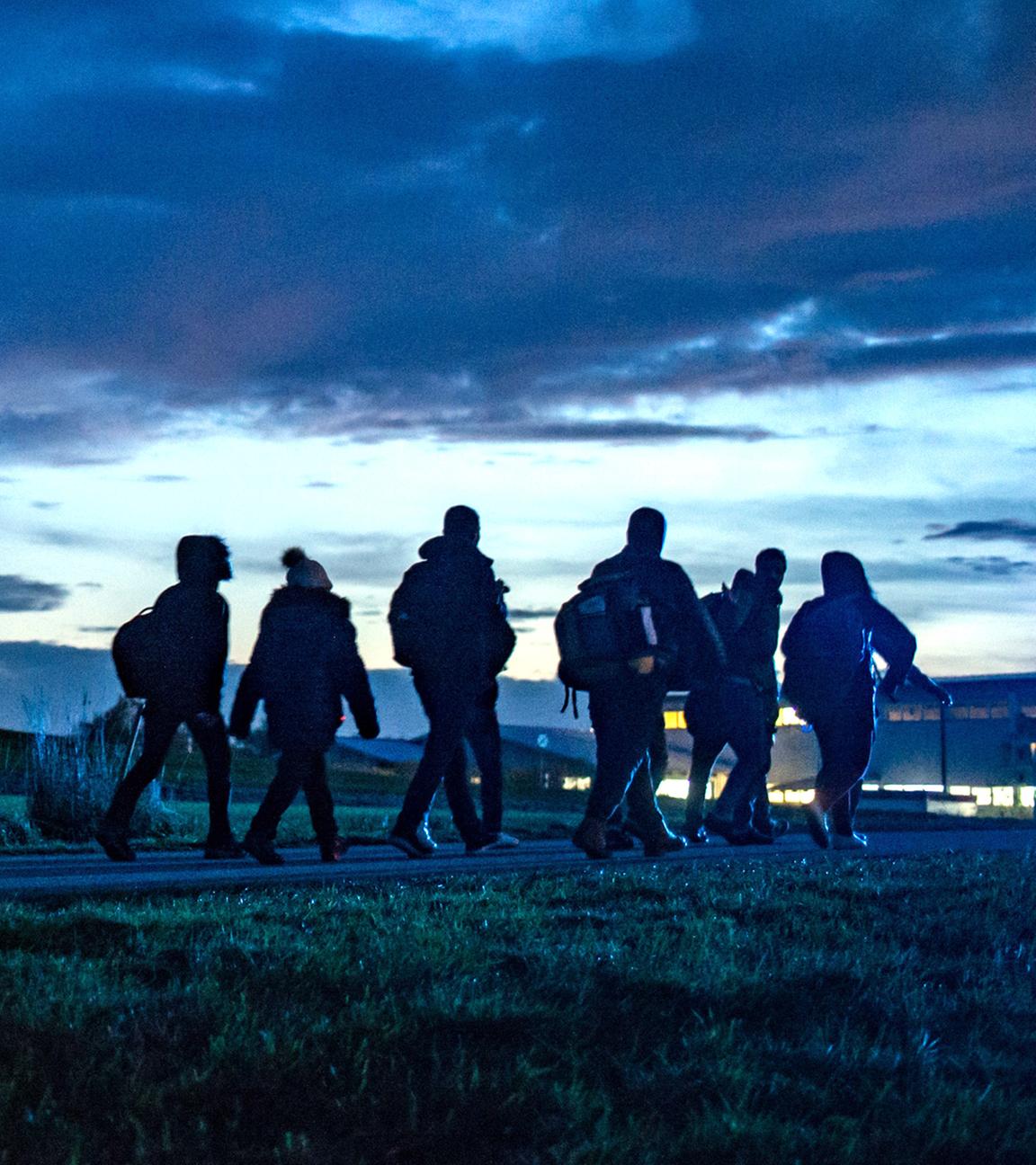 Archiv: Flüchtlinge gehen am 28.10.2015 hinter der deutsch-österreichischen Grenze in Wegscheid (Bayern) zu einer Notunterkunft