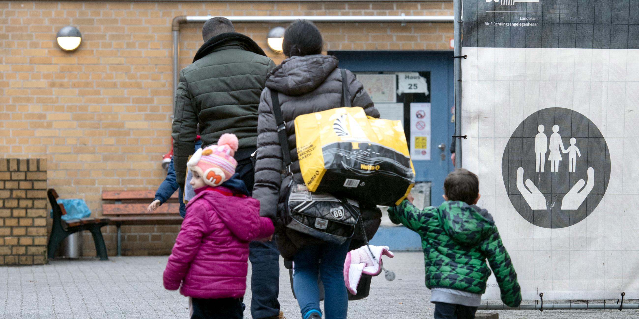 Eine geflüchtete Familie geht über das Gelände der Erstaufnahmeeinrichtung des Landesamtes für Flüchtlingsangelegenheiten (LAF) in Reinickendorf.