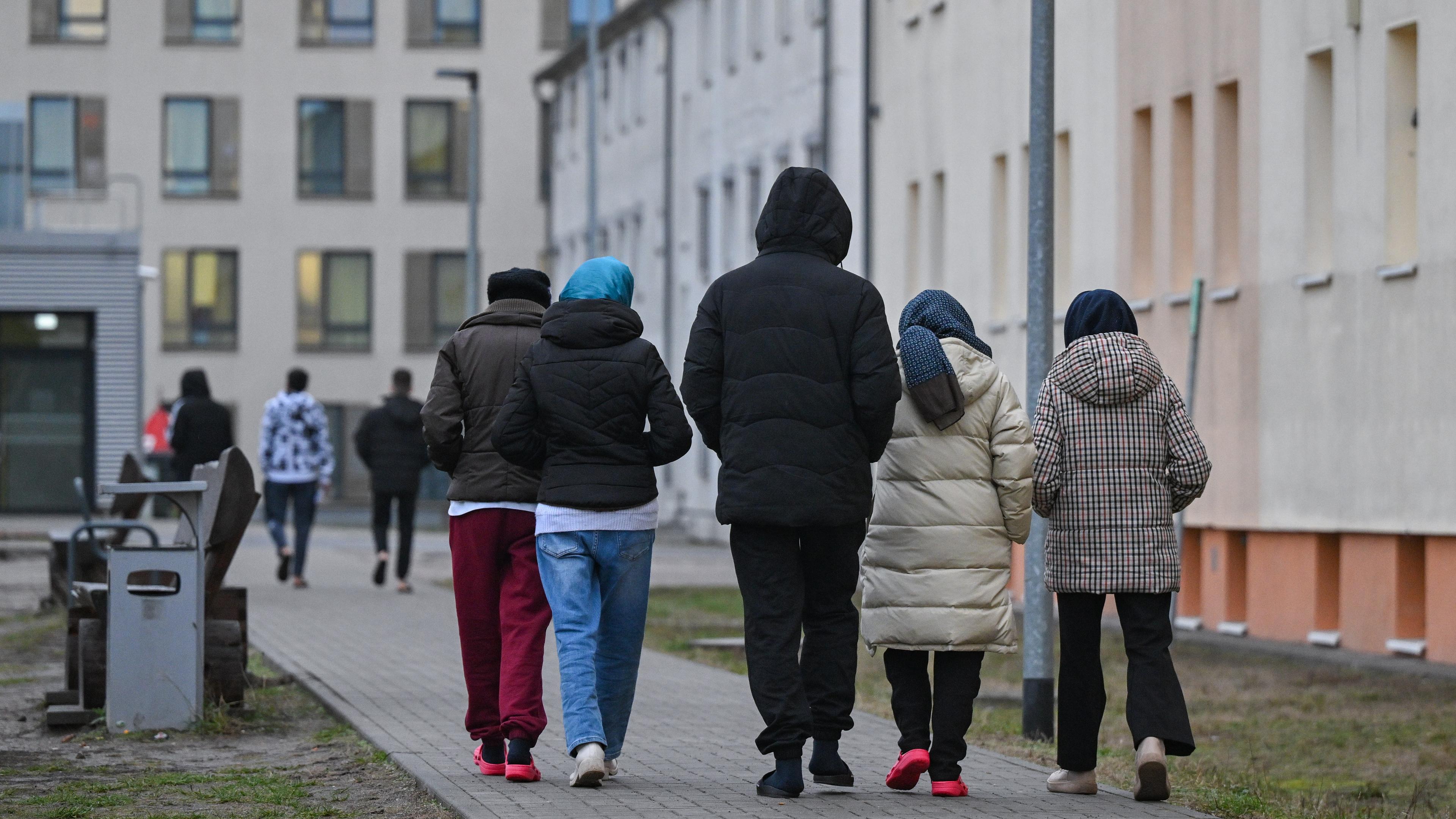 Migranten gehen über das Gelände der Zentralen Erstaufnahmeeinrichtung für Asylbewerber (ZABH) des Landes Brandenburg in Eisenhüttenstadt.