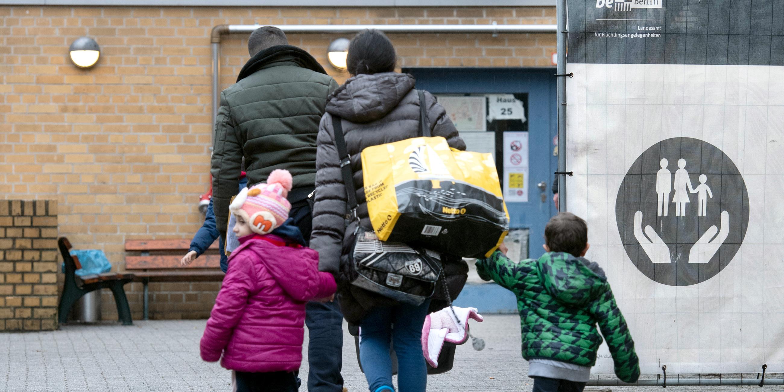 Eine geflüchtete Familie geht über das Gelände der Erstaufnahmeeinrichtung des Landesamtes für Flüchtlingsangelegenheiten (LAF) in Reinickendorf. (