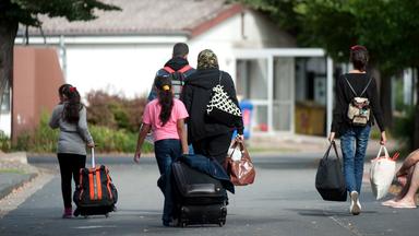 Flüchtlinge mit Koffern und Plastiktüten im Grenzdurchgangslager Friedland, Archivbild