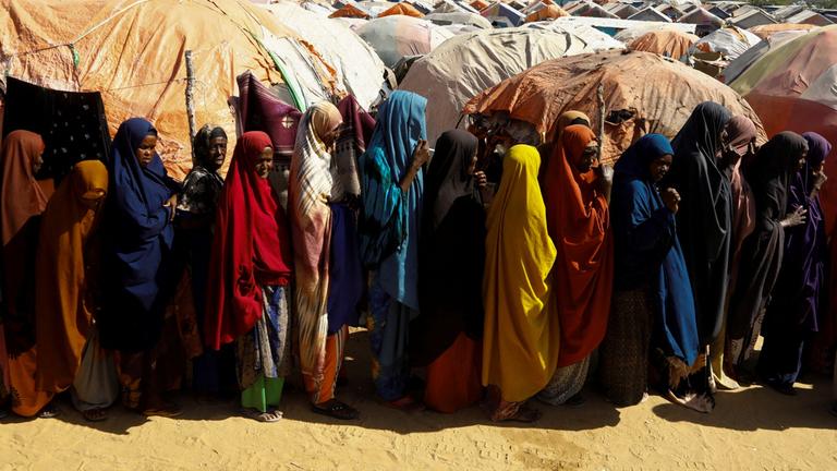Intern vertriebene Somalier stellen sich an, um während des Ramadan Iftar-Lebensmittelrationen am Stadtrand von Mogadischu zu erhalten.