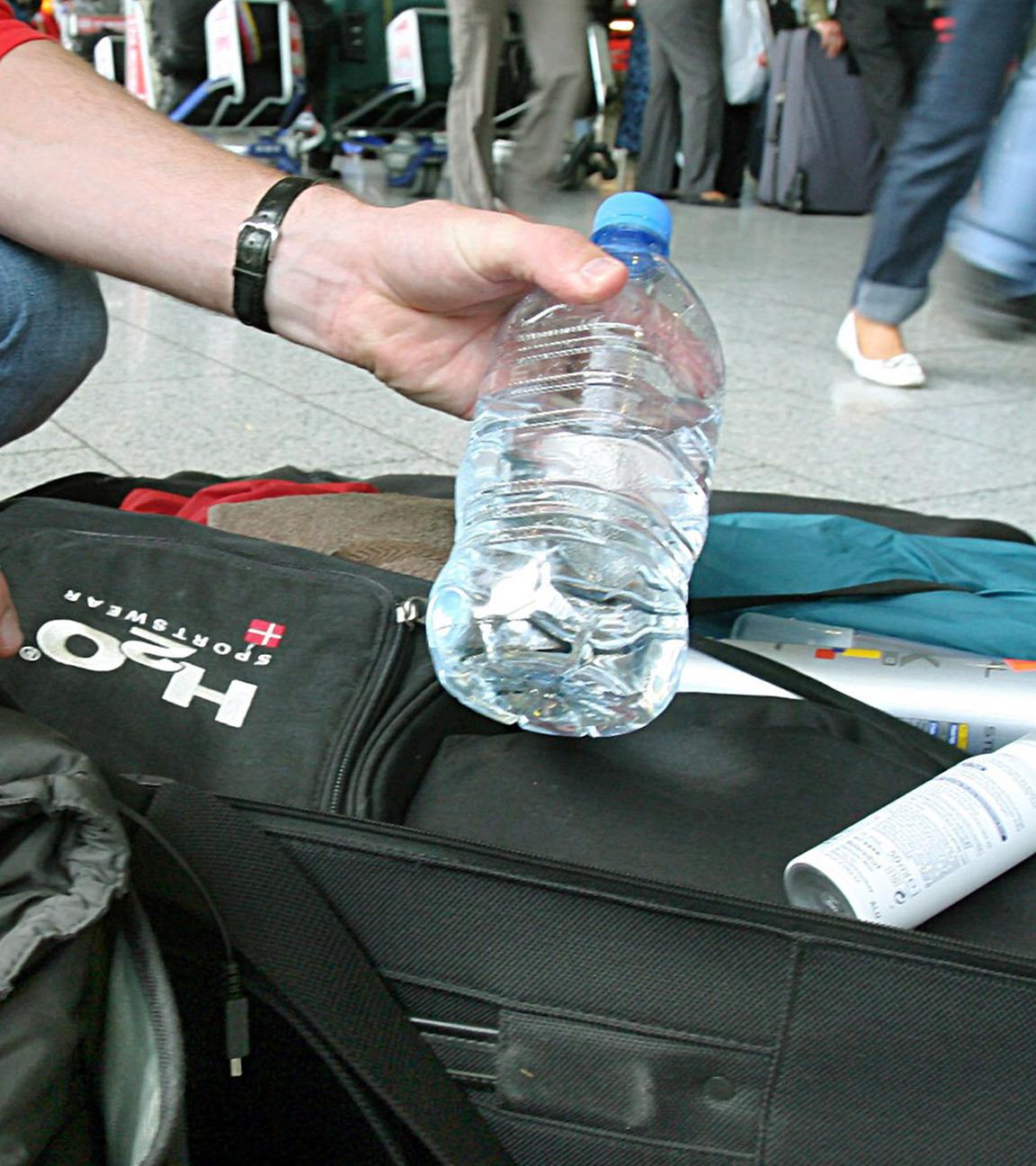 Ein Mann nimmt am Flughafen Frankfurt am Main Flüssigkeiten aus seinem Handgepäck. (Archiv)