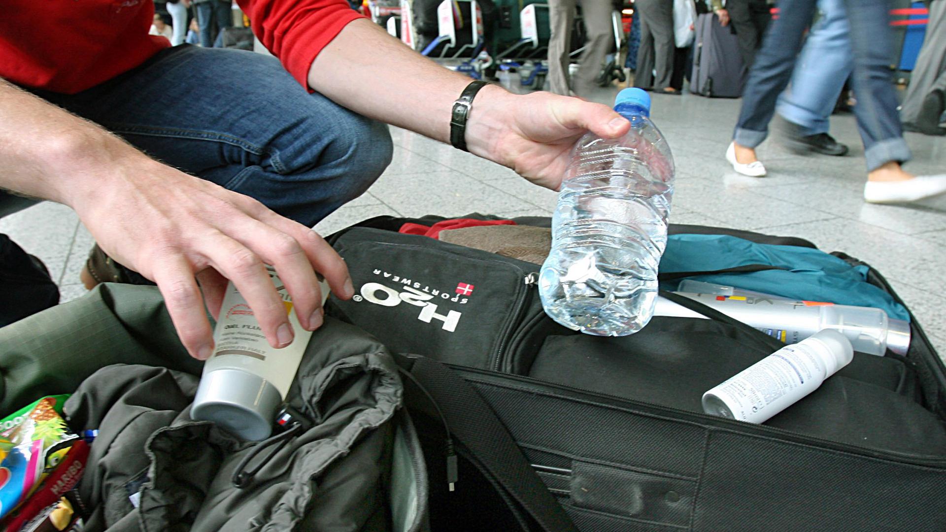 Ein Mann nimmt am Flughafen Frankfurt am Main Flüssigkeiten aus seinem Handgepäck. (Archiv)