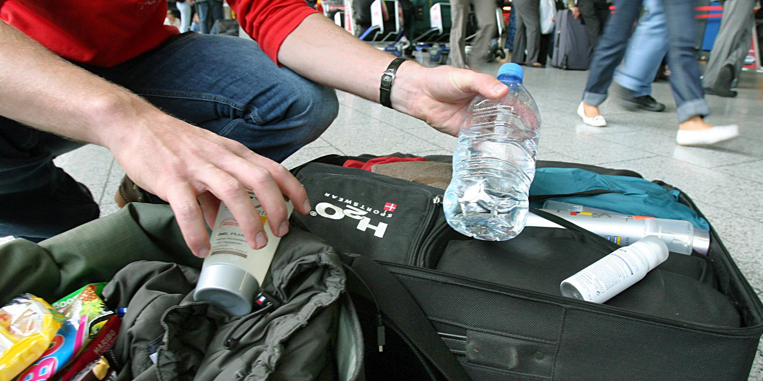 Ein Mann nimmt am Flughafen Frankfurt am Main Flüssigkeiten aus seinem Handgepäck. (Archiv)