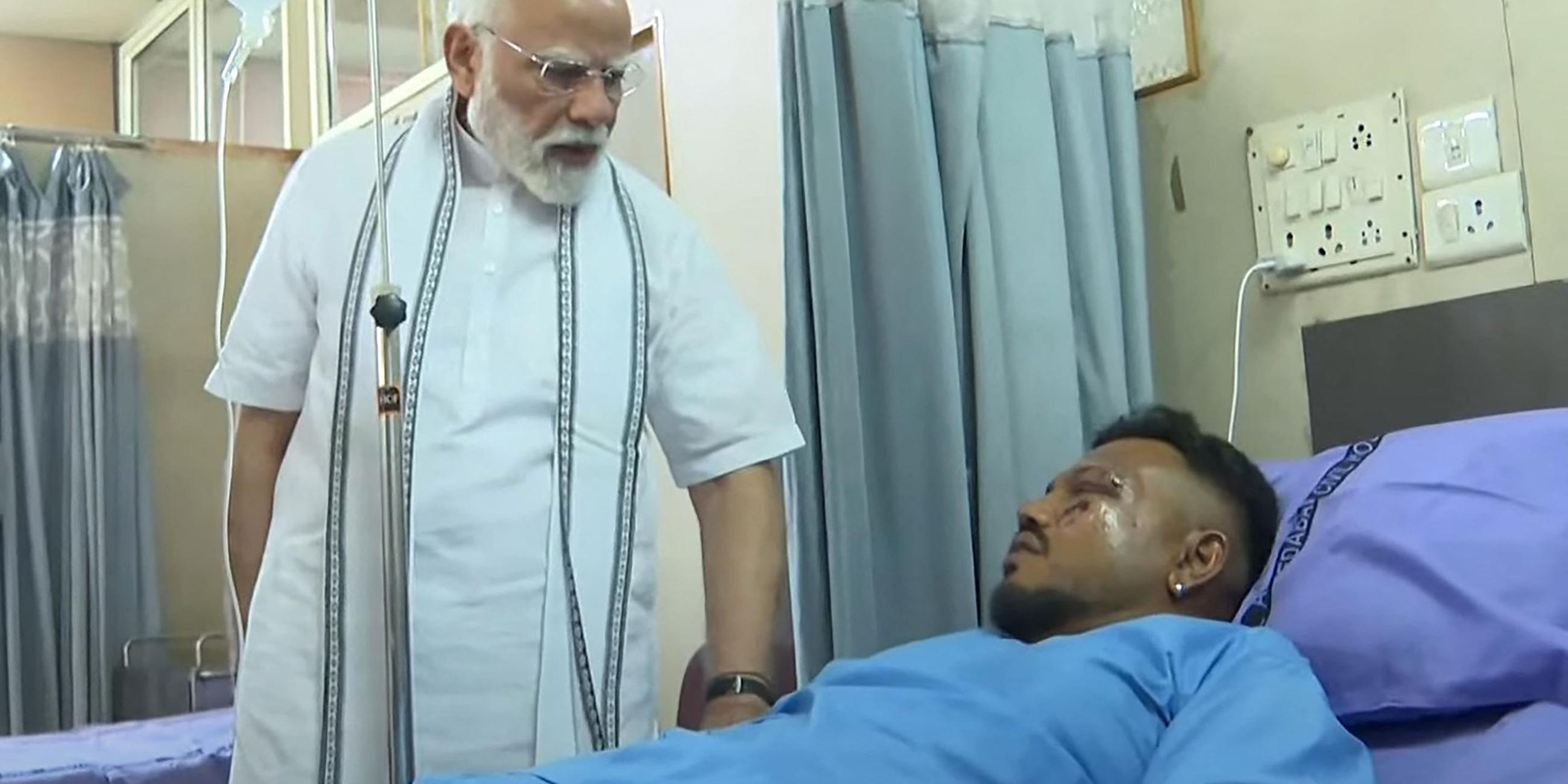 Dieser Screengrab von Videomaterial, das vom Narendra Modi Youtube Channel am 13. Juni 2025 aufgenommen und veröffentlicht wurde, zeigt Indiens Premierminister Narendra Modi (L) bei einem Treffen mit Vishwash Kumar Ramesh, dem einzigen Überlebenden des Absturzes von Air India Flug 171, in einem Krankenhaus in Ahmedabad.
