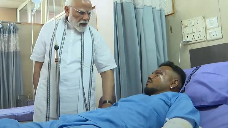 Dieser Screengrab von Videomaterial, das vom Narendra Modi Youtube Channel am 13. Juni 2025 aufgenommen und veröffentlicht wurde, zeigt Indiens Premierminister Narendra Modi (L) bei einem Treffen mit Vishwash Kumar Ramesh, dem einzigen Überlebenden des Absturzes von Air India Flug 171, in einem Krankenhaus in Ahmedabad.